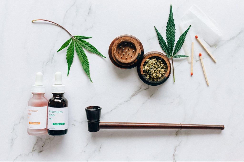Top view of cannabis products including CBD oils, leaves, and smoking accessories. Source - Pexels